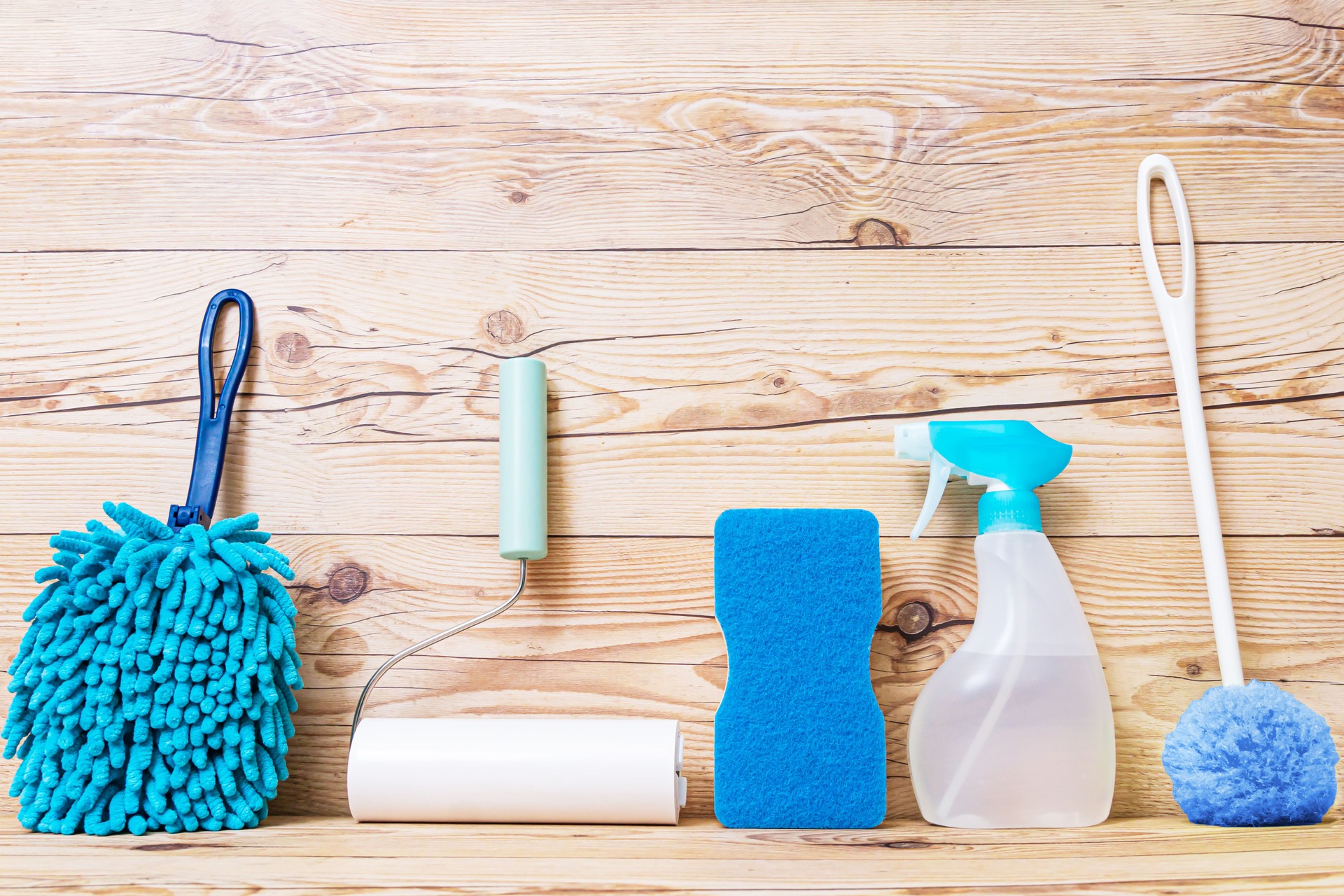 Herramientas de limpieza sobre fondo de madera.